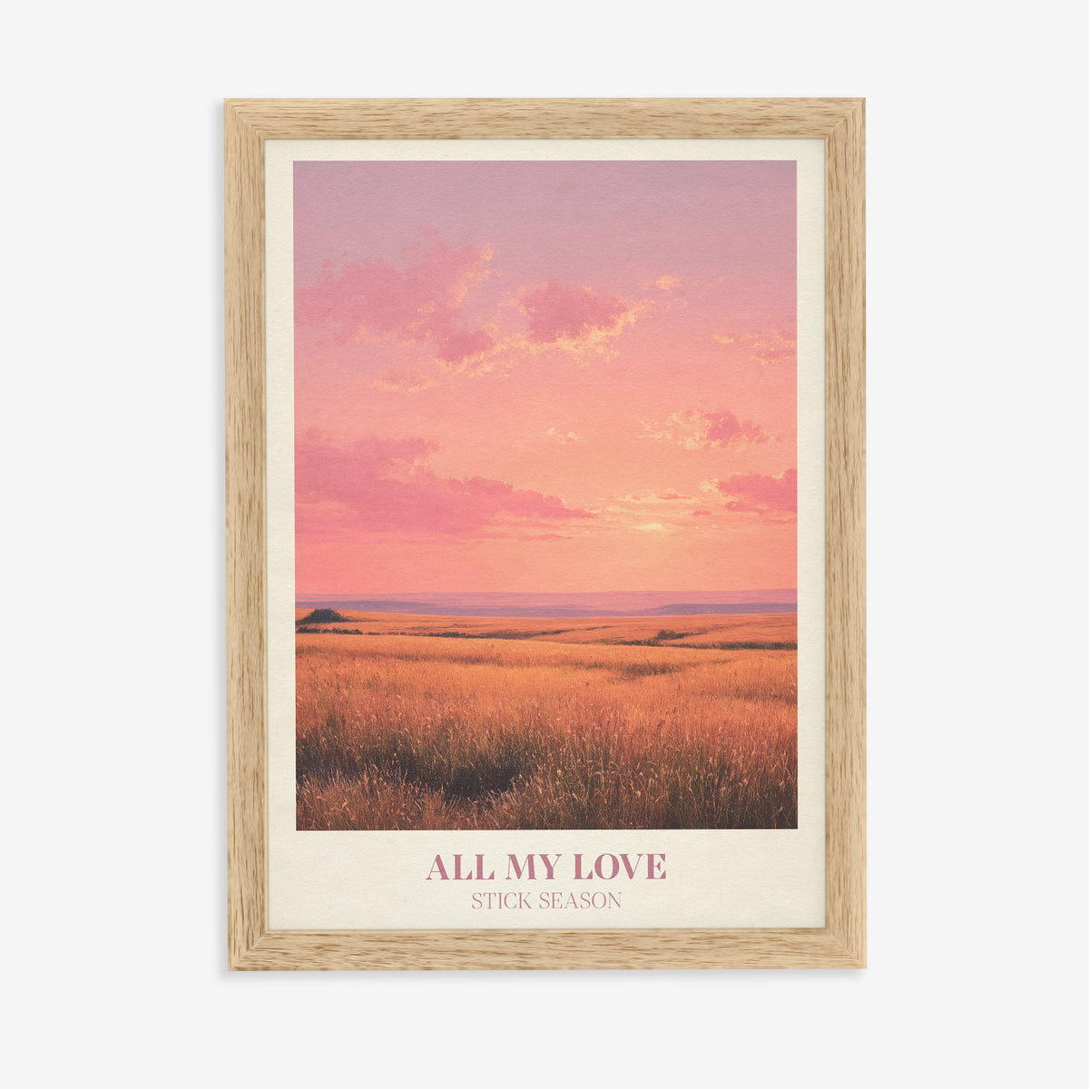 All My Love Noah Kahan print of a golden field under a glowing pink sunset, in an oak frame on a plain wall