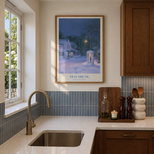 Dial Drunk Noah Kahan print of a phone box on a snowy village street at night, hung in a sunlit kitchen with blue tiles