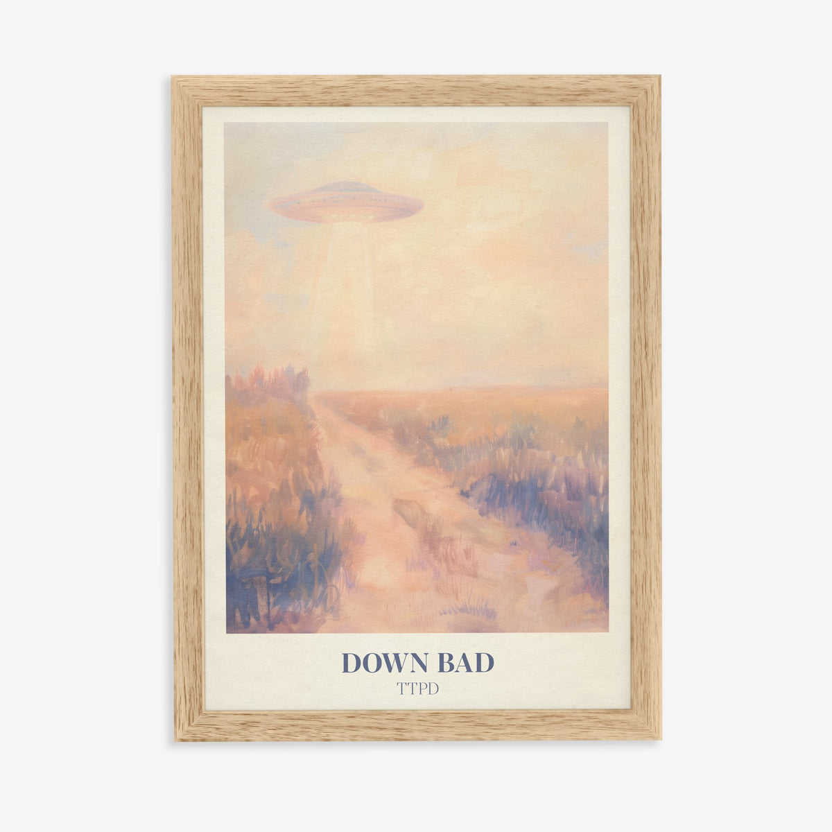 Down Bad Taylor Swift print of a UFO beaming light over a dusty track through golden fields, in an oak frame on a plain wall