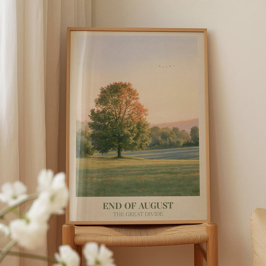 End of August Noah Kahan print of a lone tree in a late-summer field, framed on a wooden chair beside white blossom