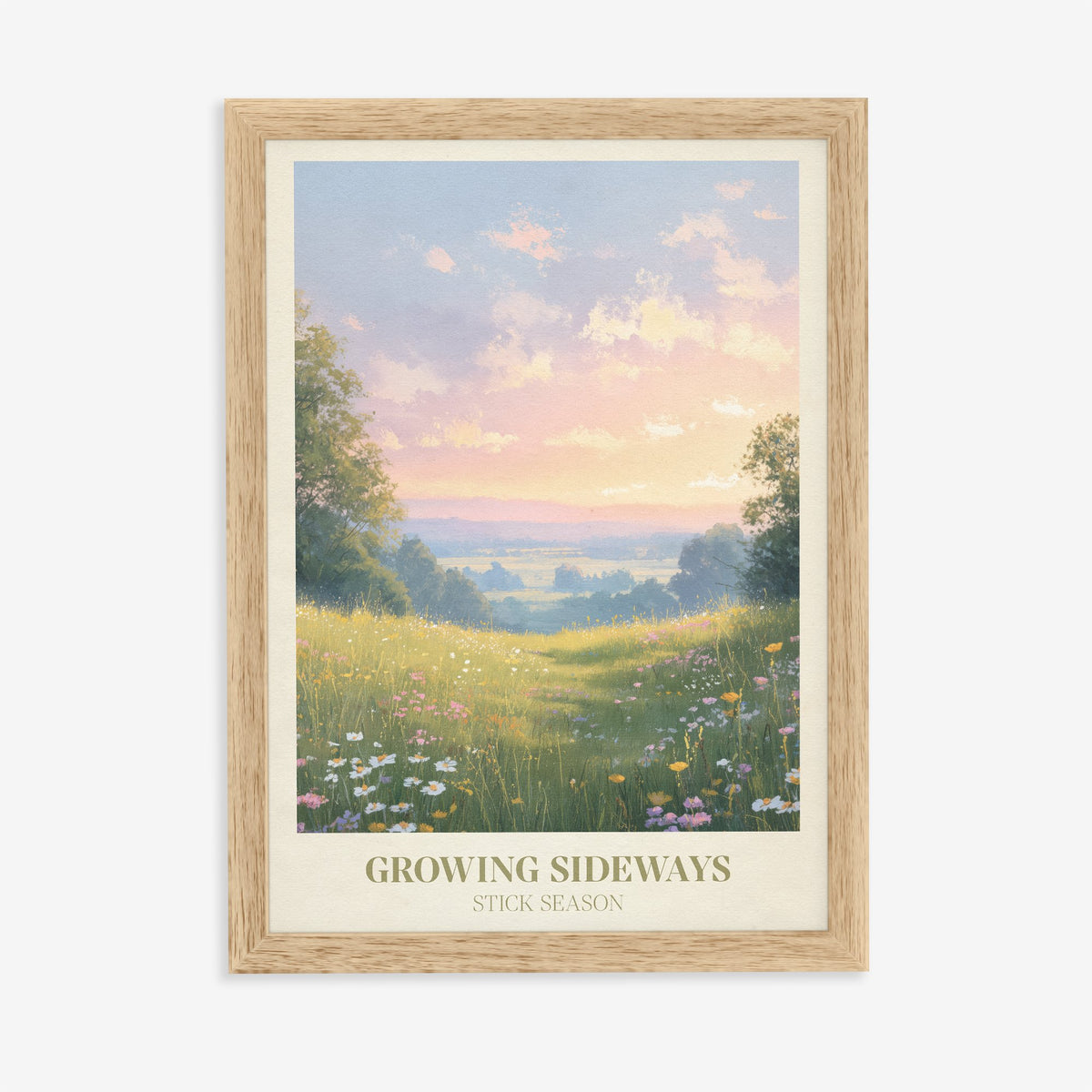 Growing Sideways Noah Kahan print of a wildflower meadow at sunset, in an oak frame on a plain wall