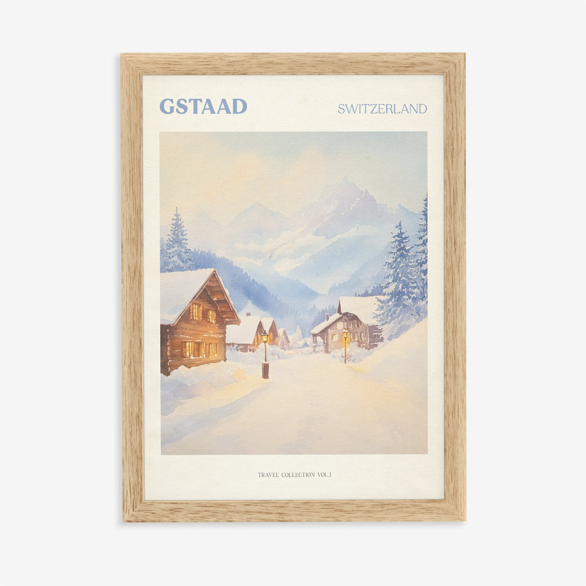 Gstaad travel print of snow-covered wooden chalets and pine trees below the Swiss Alps, in an oak frame on a plain wall