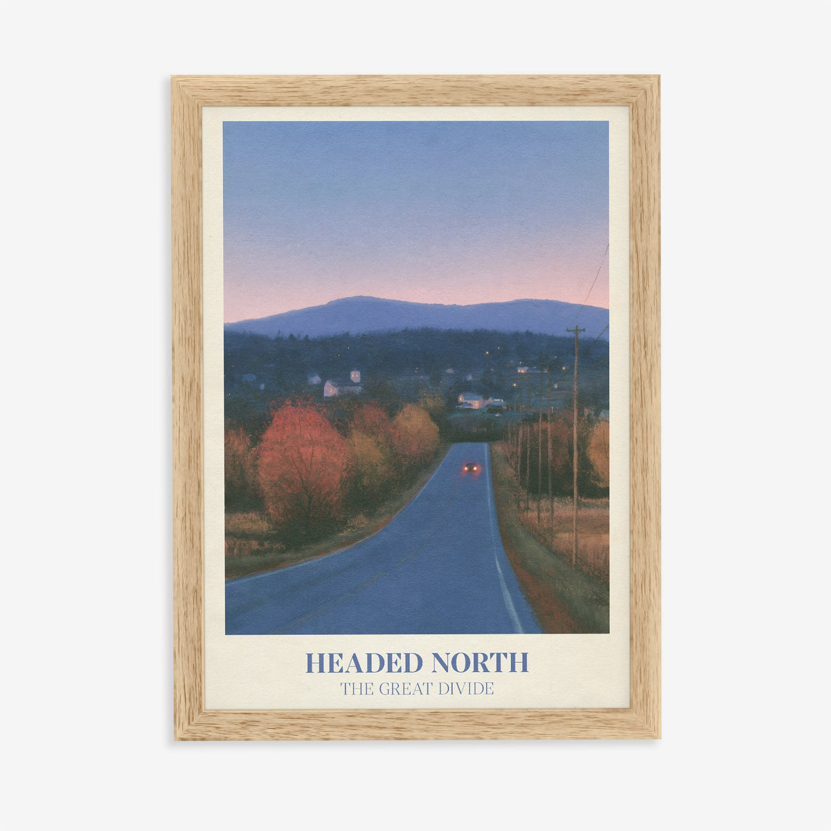 Headed North Noah Kahan print of a country road through autumn trees at dusk, in an oak frame on a plain wall