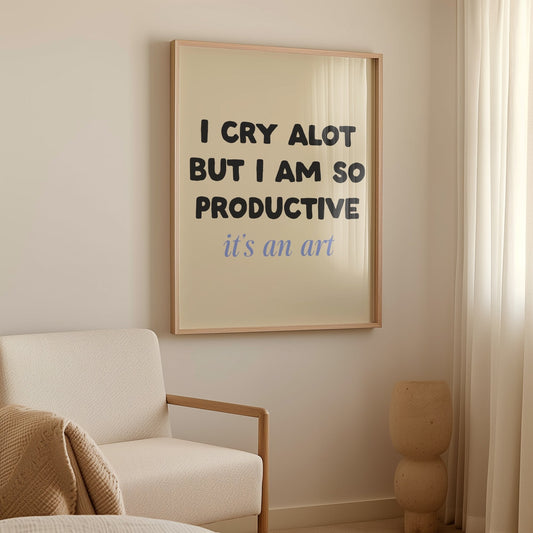 I Cry A Lot But I’m So Productive Taylor Swift lyric print of black and blue lettering on cream, framed above a cream armchair
