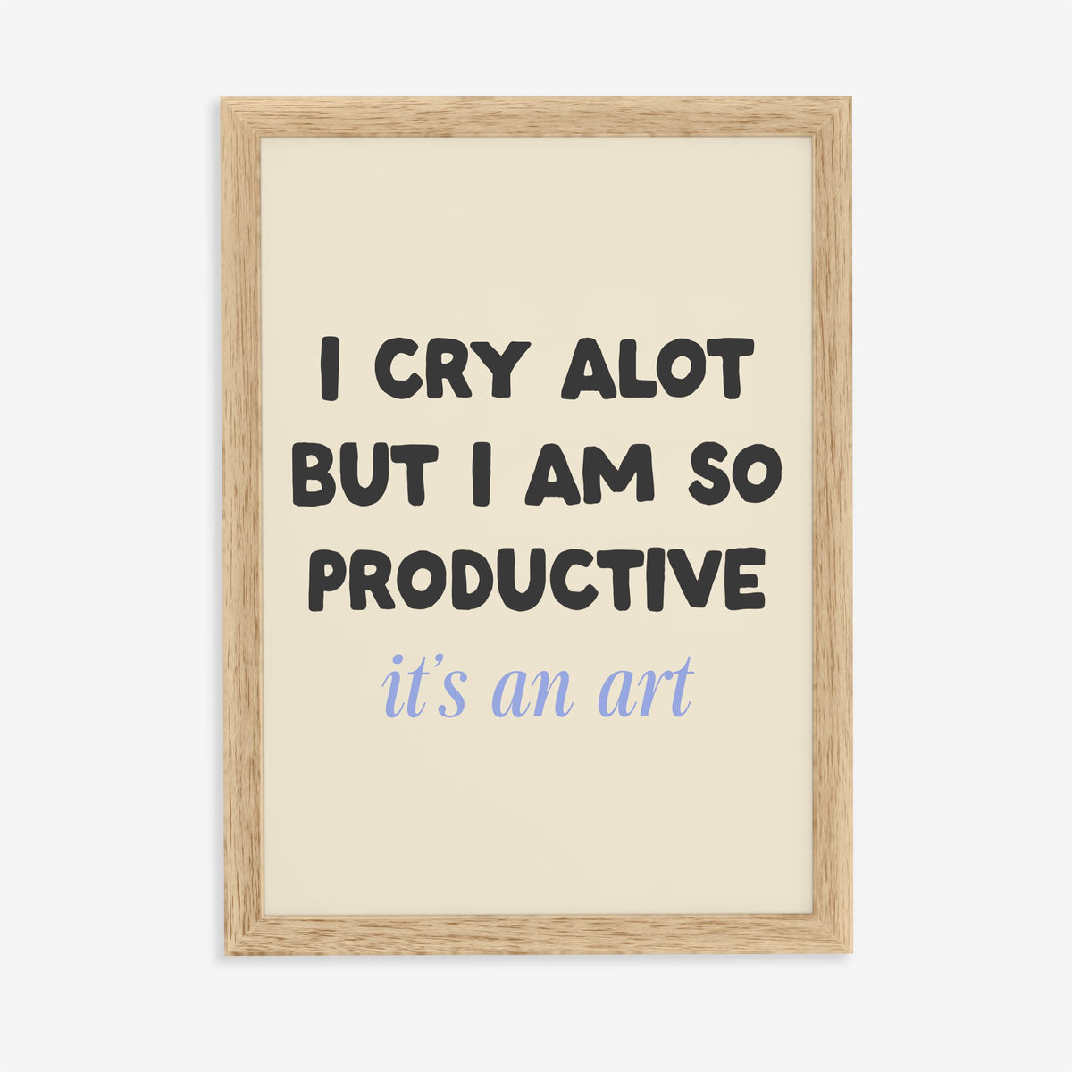 I Cry A Lot But I’m So Productive Taylor Swift lyric print of black and blue lettering on cream, in an oak frame on a plain wall