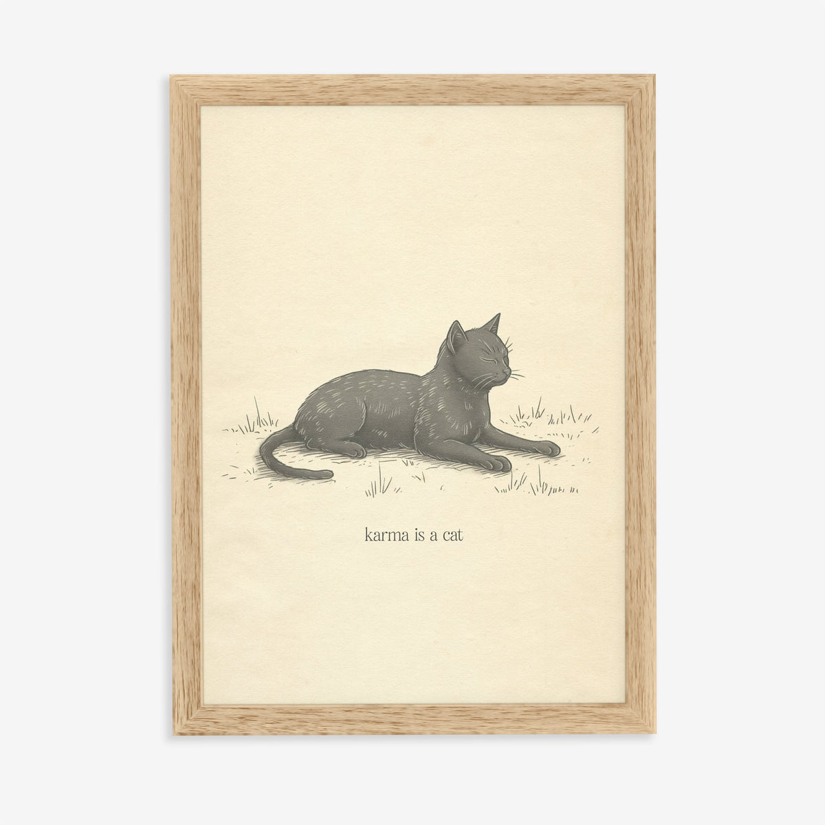 Karma Is A Cat Minimal Taylor Swift print of a sketch of a grey cat dozing in grass, in an oak frame on a plain wall