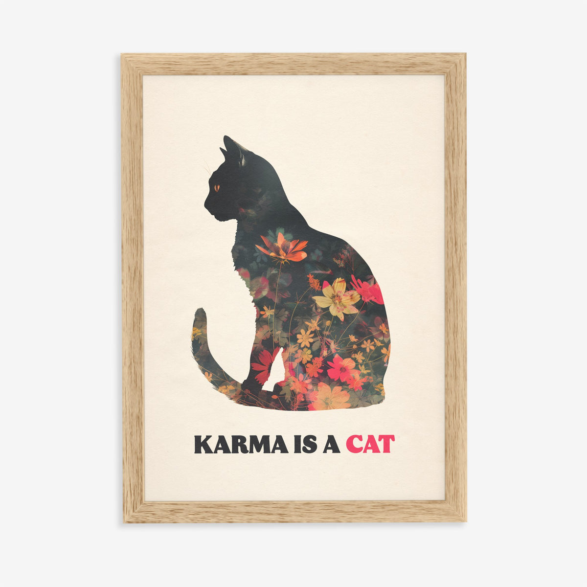 Karma Is A Cat Taylor Swift print of a black cat silhouette filled with red and orange flowers, in an oak frame on a plain wall