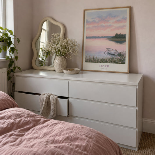 Lover Taylor Swift print of a rowing boat on a pink lake, leaning on a white dresser beside a wavy mirror