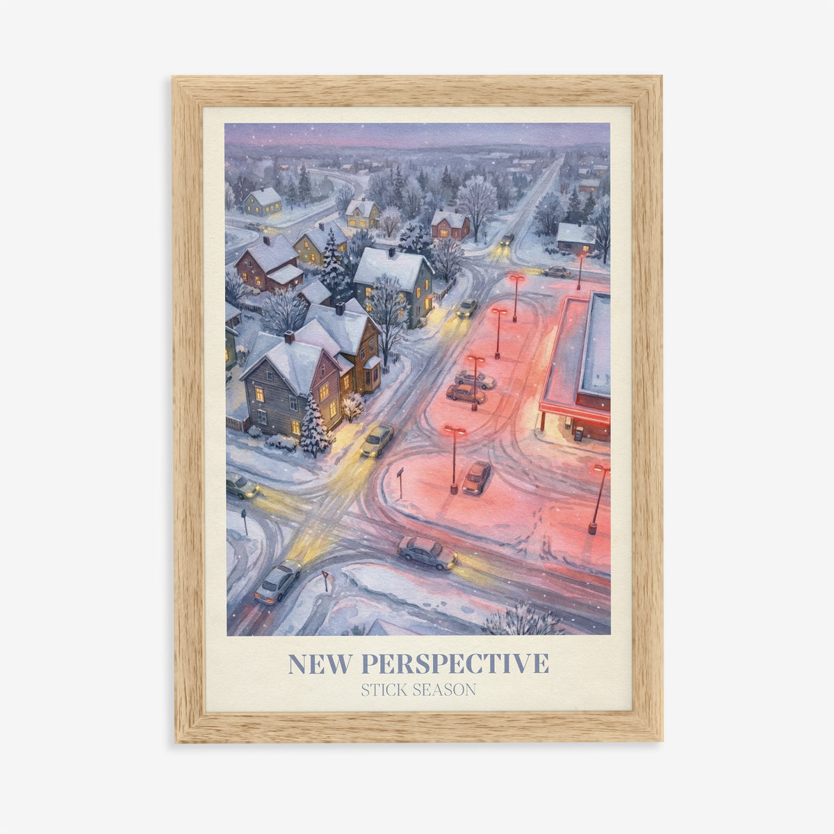 New Perspective Noah Kahan print of a snowy small town at night with a red-lit car park, in an oak frame on a plain wall