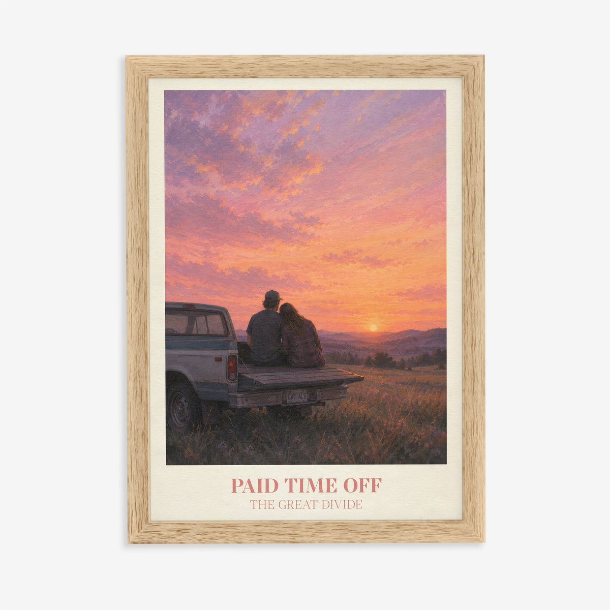 Paid Time Off Noah Kahan print of a couple on a truck watching a pink sunset, in an oak frame on a plain wall