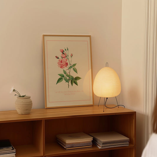 So Tell Me Everything Is Not About Me Taylor Swift print of a pink rose in a thin pink border, framed on a shelf beside a paper lantern
