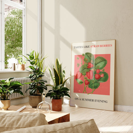 Strawberries On A Summer Evening Harry Styles print of strawberries on coral red, framed, leaning against a wall beside potted plants