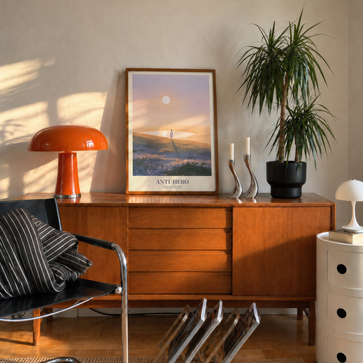 Anti-Hero Taylor Swift print of a lone figure by a lake at sunset, leaning on a mid-century sideboard beside an orange lamp