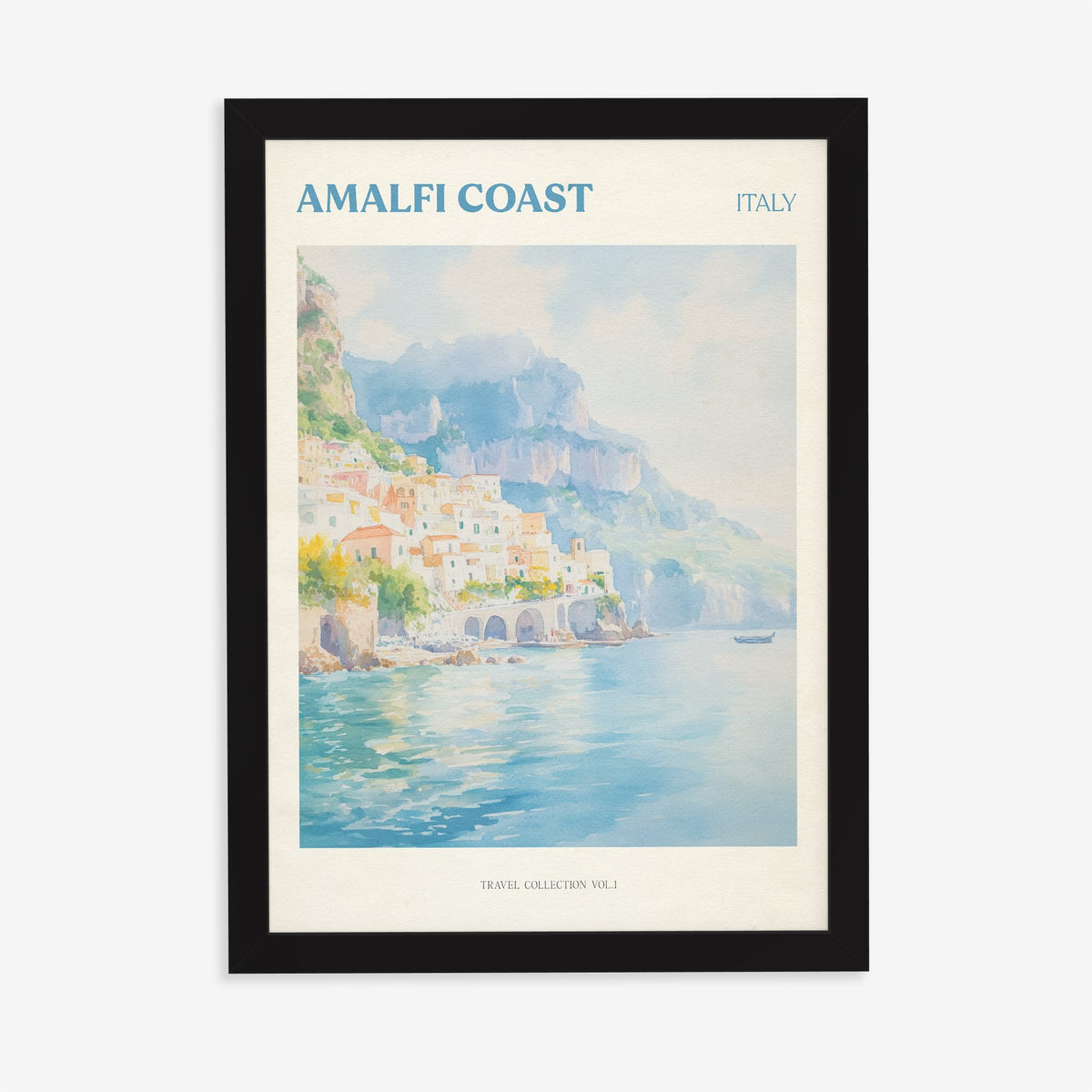 Amalfi Coast travel print of pastel houses on the cliffs above a turquoise sea, in a black frame on a plain wall
