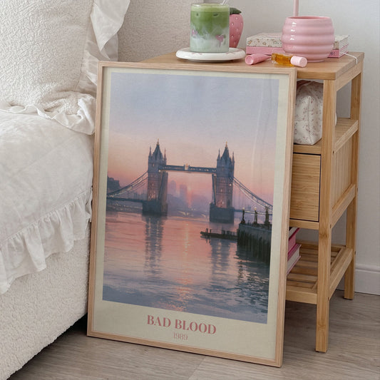 Bad Blood Taylor Swift print of Tower Bridge at a pink sunset, leaning beside a bed and a bamboo nightstand