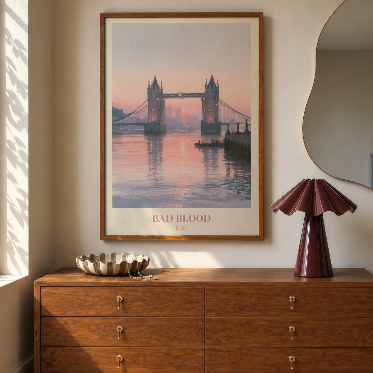 Bad Blood Taylor Swift print of Tower Bridge at a pink sunset, hung above a walnut dresser beside a wavy mirror and a pleated lamp