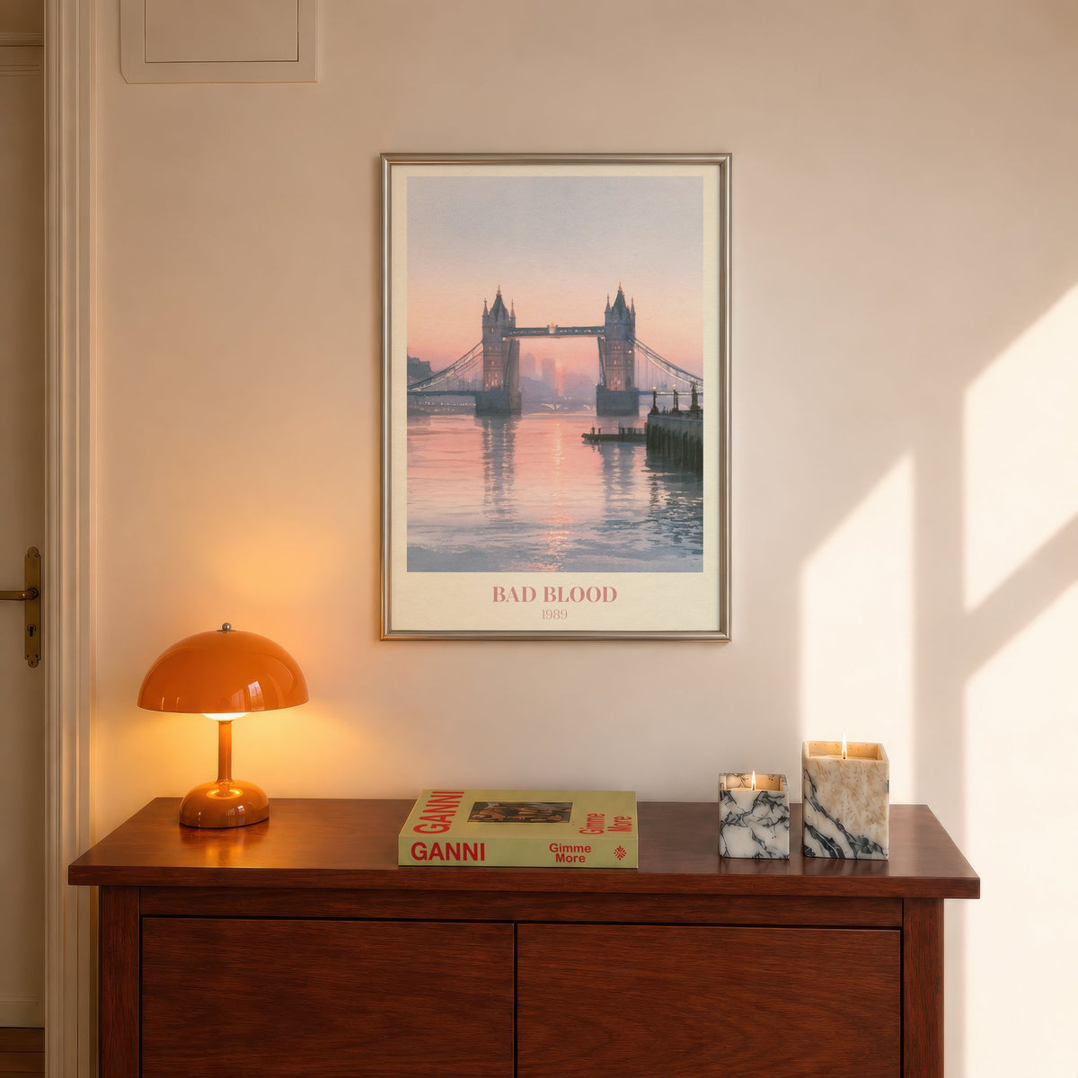 Bad Blood Taylor Swift print of Tower Bridge at a pink sunset, hung above a hall console beside an orange lamp