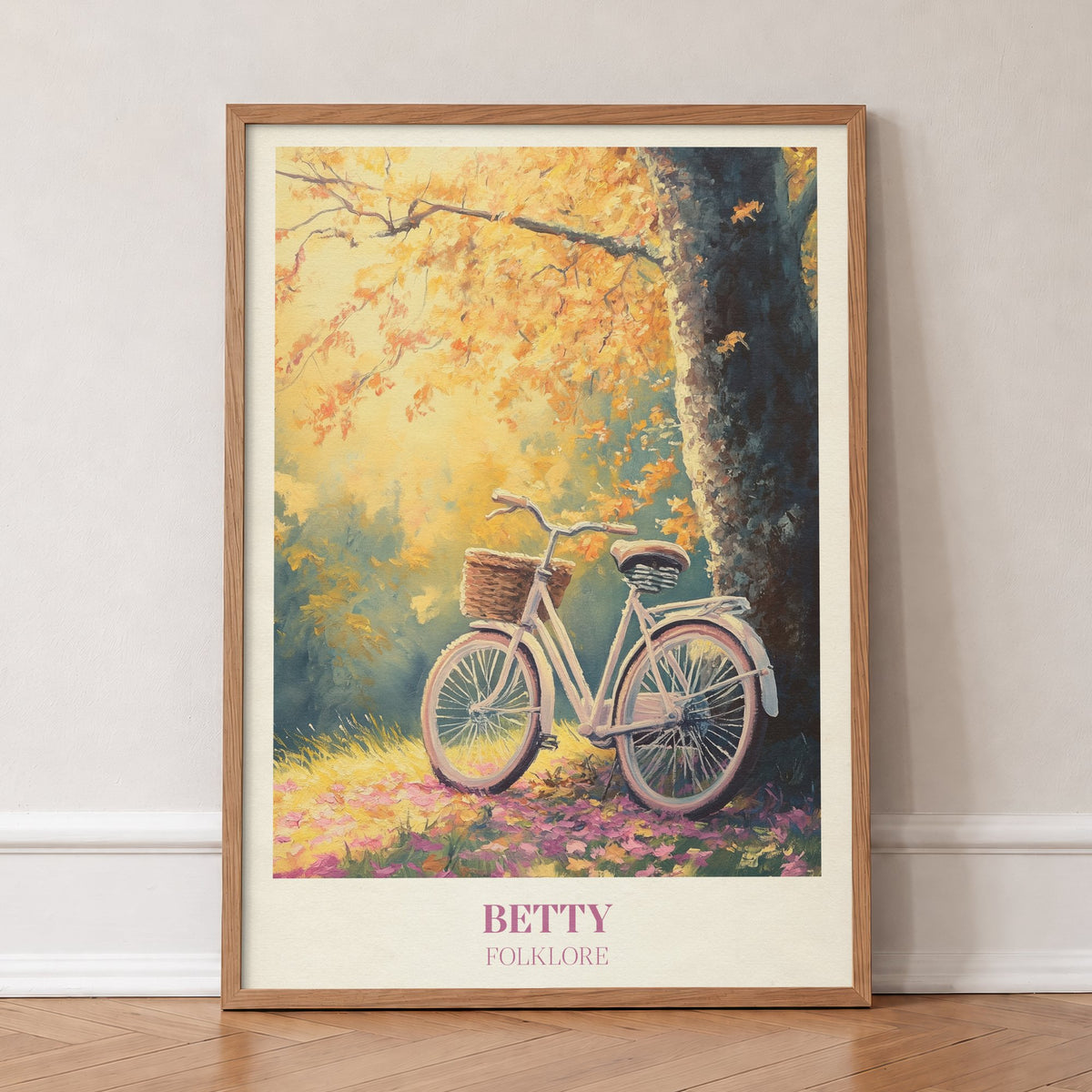 Betty Taylor Swift print of a white bicycle with a basket under an autumn tree, in an oak frame, leaning against a wall on a herringbone floor