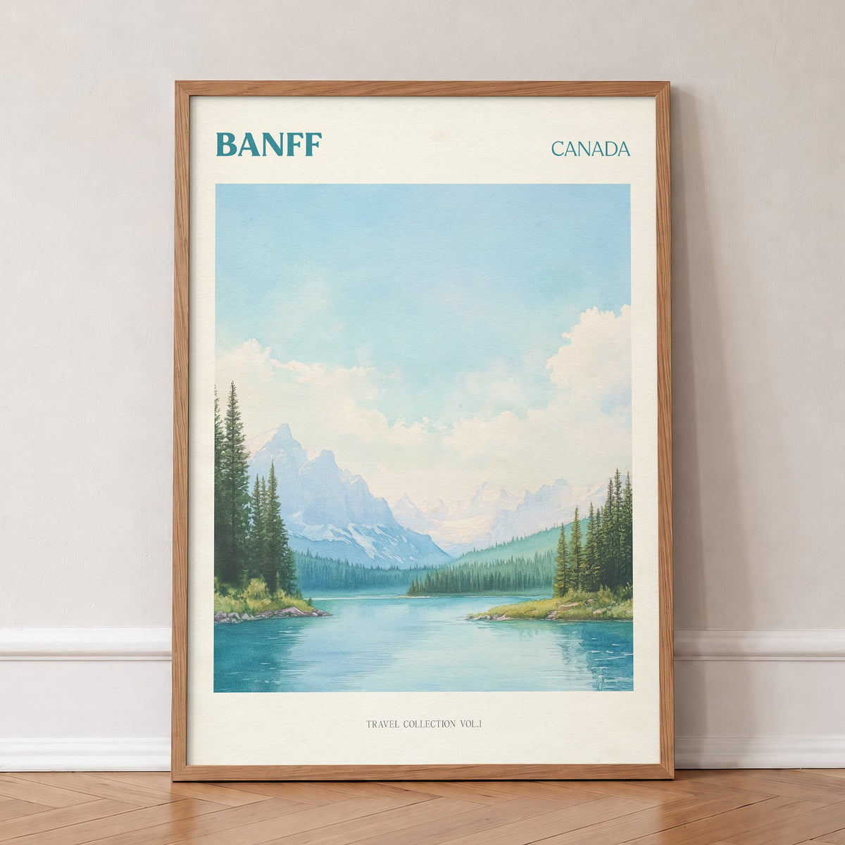 Banff travel print of snowy mountains and pine trees around a turquoise lake, in an oak frame, leaning against a wall on a herringbone floor