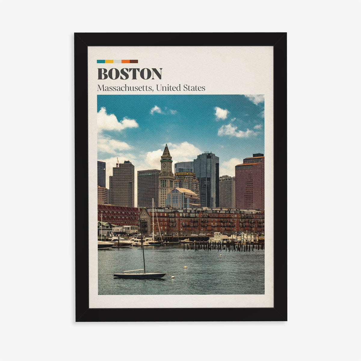 Boston travel print of the harbour skyline and Custom House clock tower behind a small sailboat, in a black frame on a plain wall