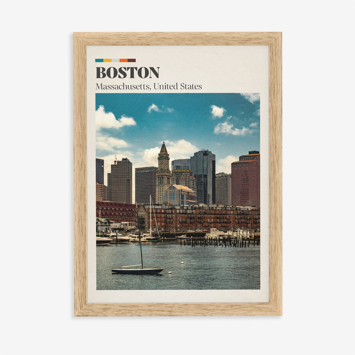 Boston travel print of the harbour skyline and Custom House clock tower behind a small sailboat, in an oak frame on a plain wall