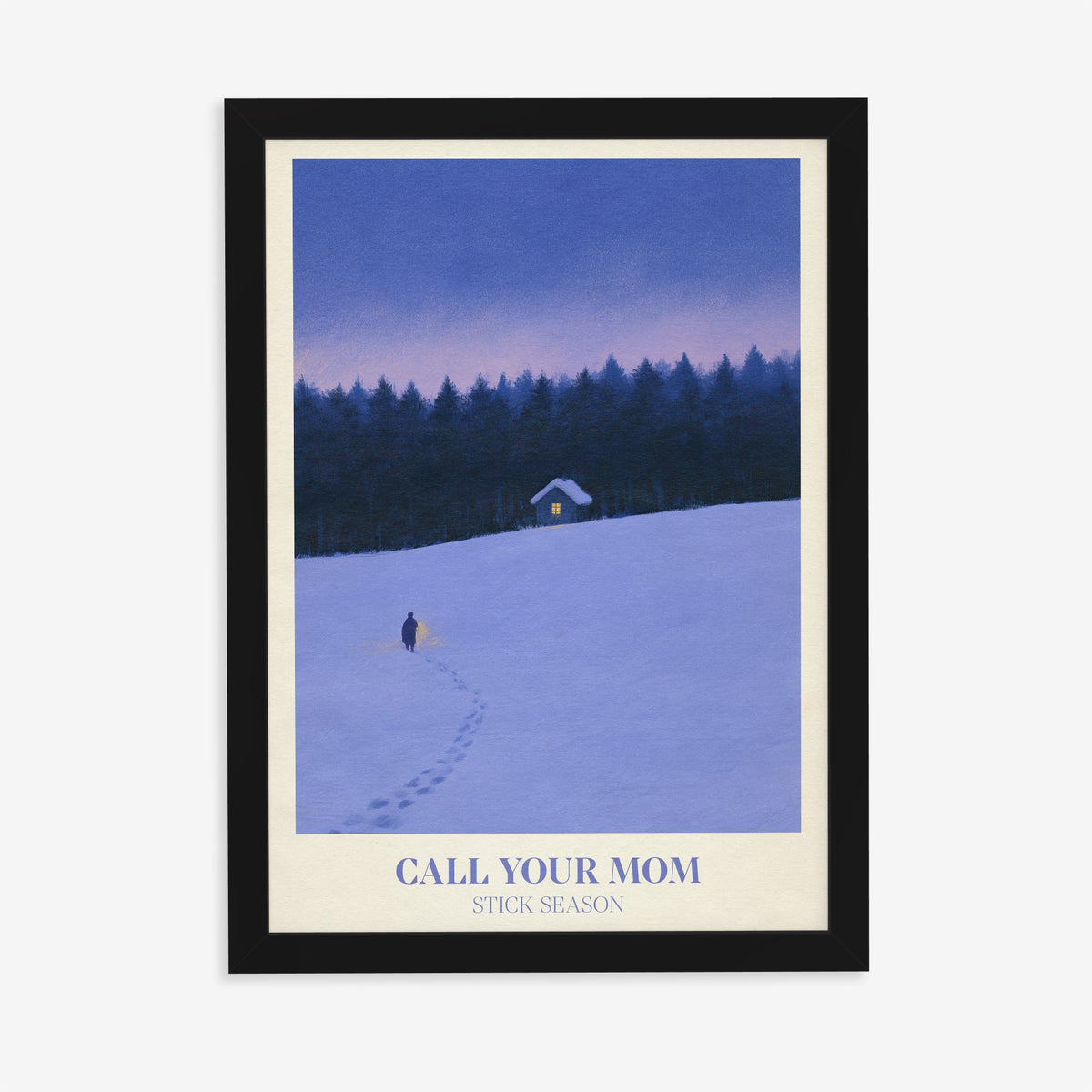 Call Your Mom Winter Noah Kahan print of a lone walker heading to a lit cabin in the snow, in a black frame on a plain wall