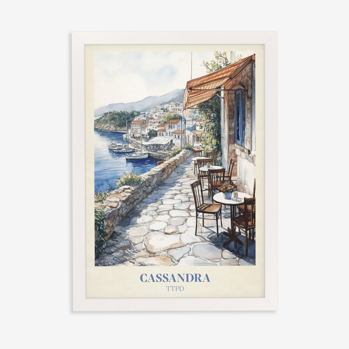 Cassandra Taylor Swift print of a cobbled café terrace above a whitewashed harbour town, in a white frame on a plain wall