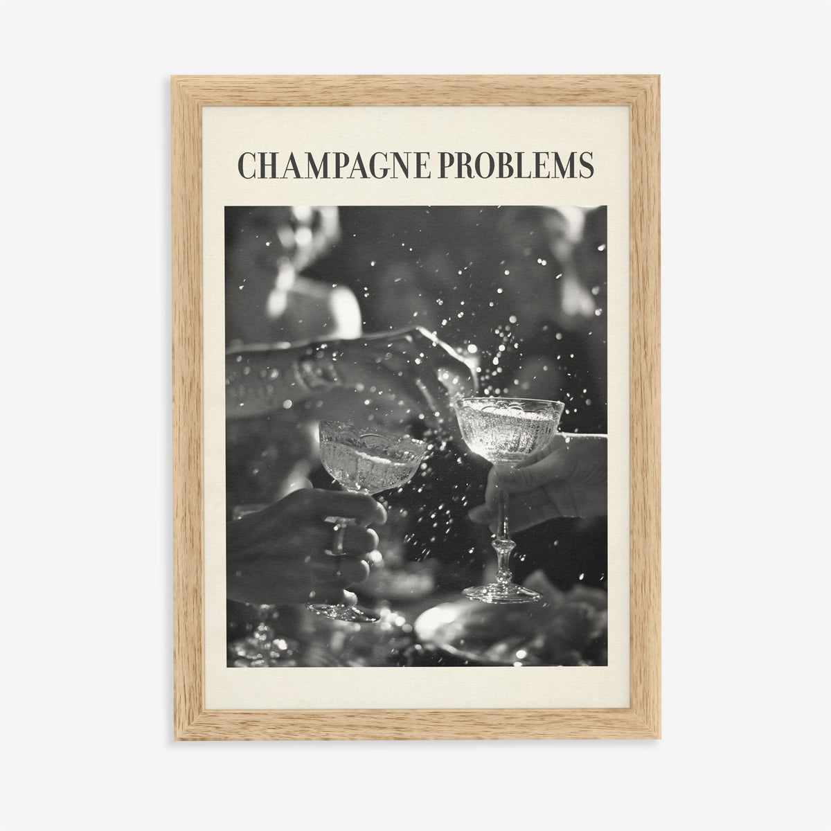 Champagne Problems Retro Taylor Swift print of two champagne coupes clinking in black and white, in an oak frame on a plain wall