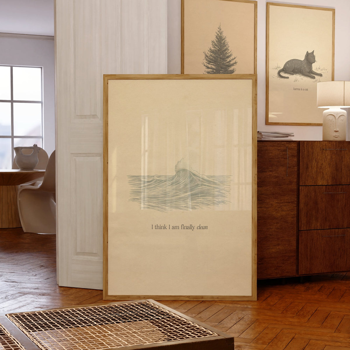 Clean Minimal Taylor Swift print of a line-drawn breaking wave on cream paper, framed, leaning against a chest of drawers