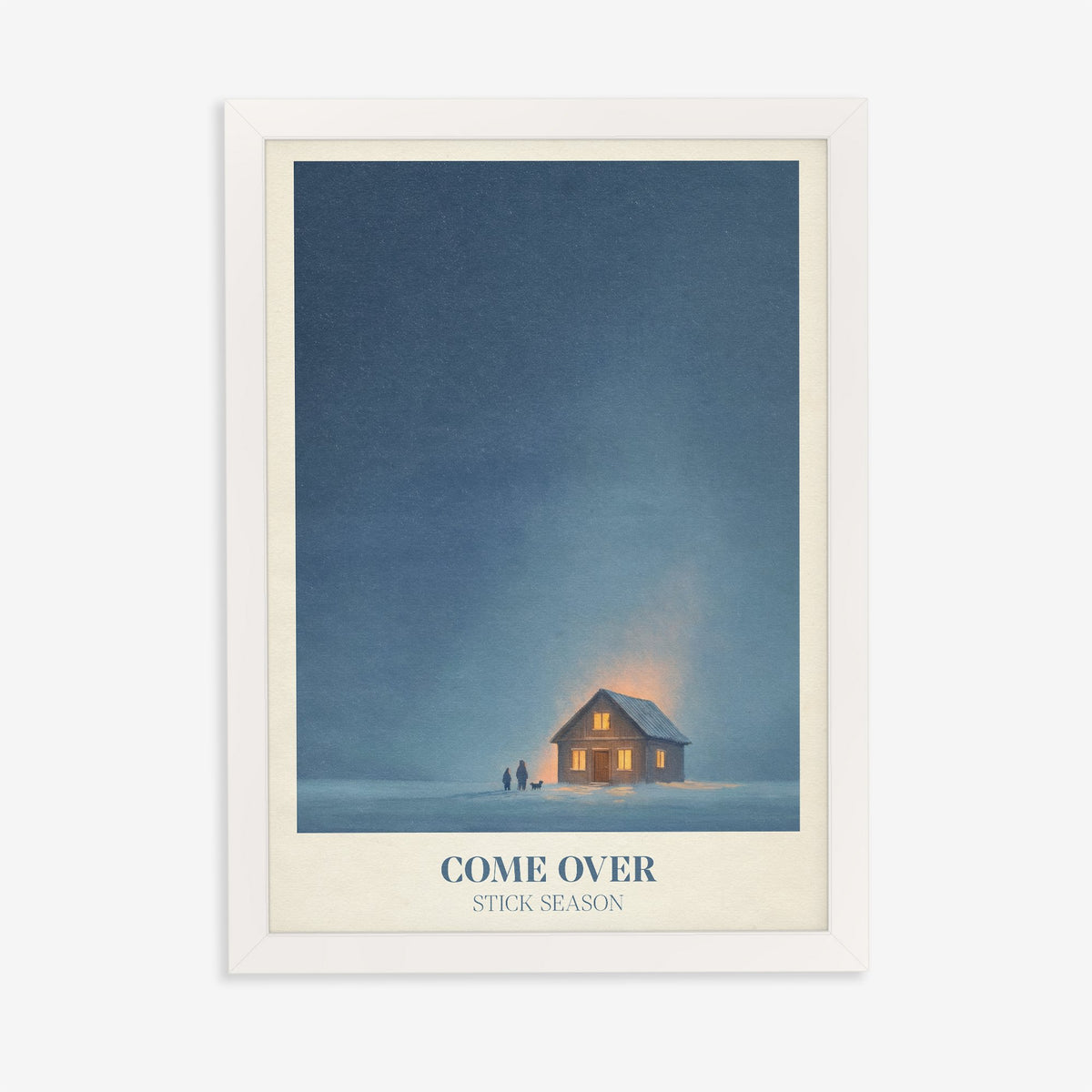 Come Over Noah Kahan print of a warm glowing cabin under a deep blue winter sky, in a white frame on a plain wall