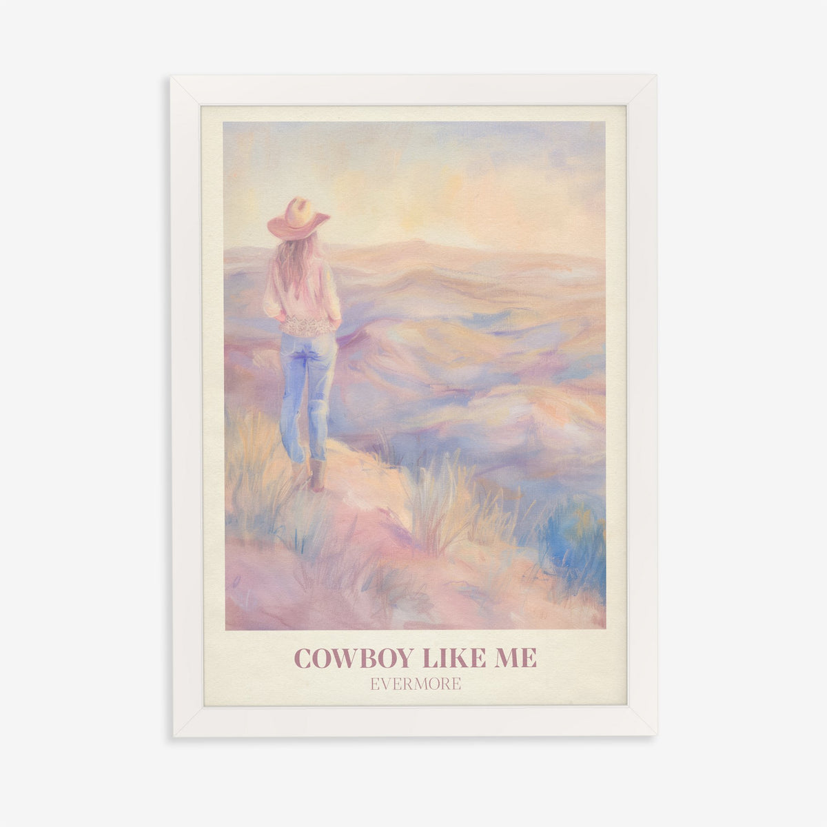 Cowboy Like Me Taylor Swift print of a cowgirl looking out over pastel hills at sunset, in a white frame on a plain wall