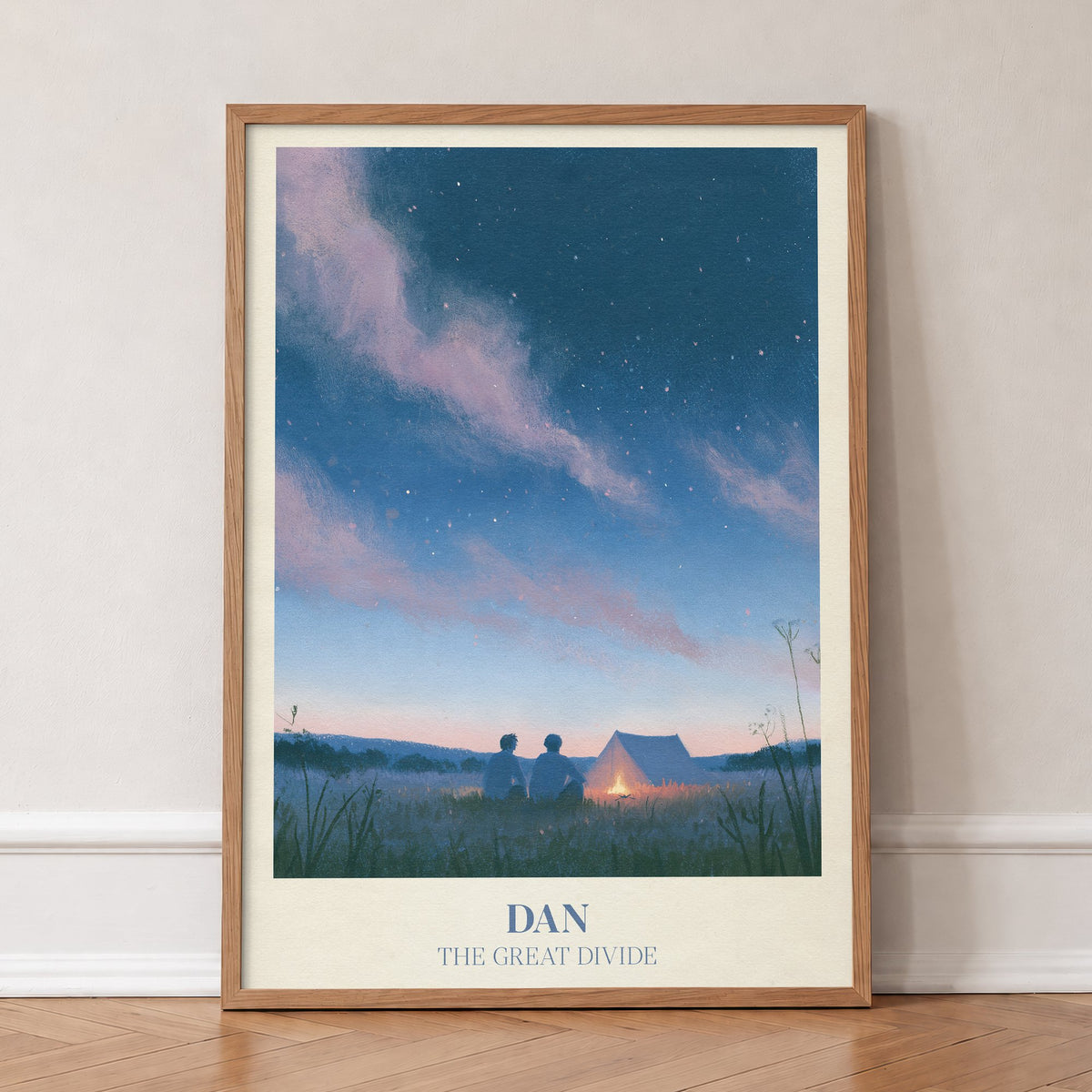 Dan Noah Kahan print of two friends by a campfire under the stars, in an oak frame, leaning against a wall on a herringbone floor