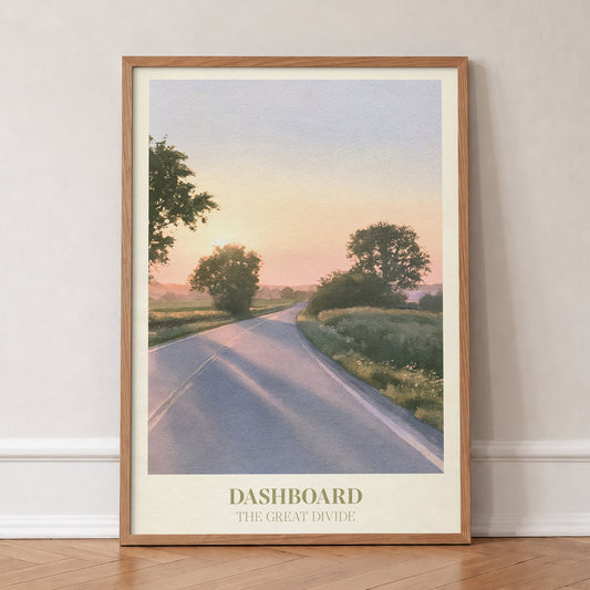 Dashboard Noah Kahan print of an empty country road at sunset, in an oak frame, leaning against a wall on a herringbone floor