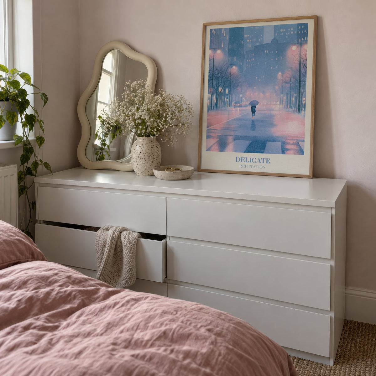 Delicate Taylor Swift print of a rainy city street at night, leaning on a white dresser beside a wavy mirror