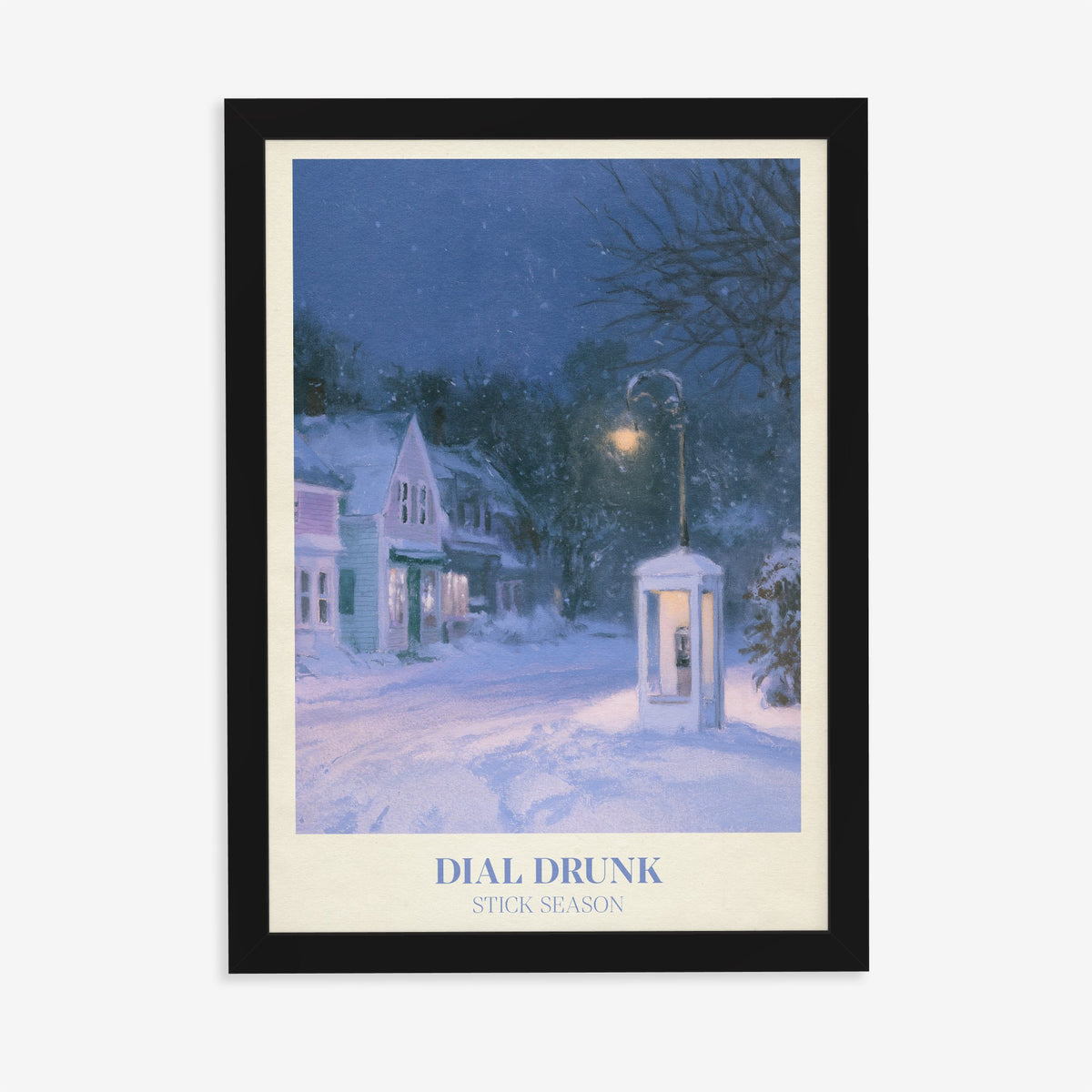 Dial Drunk Noah Kahan print of a phone box on a snowy village street at night, in a black frame on a plain wall