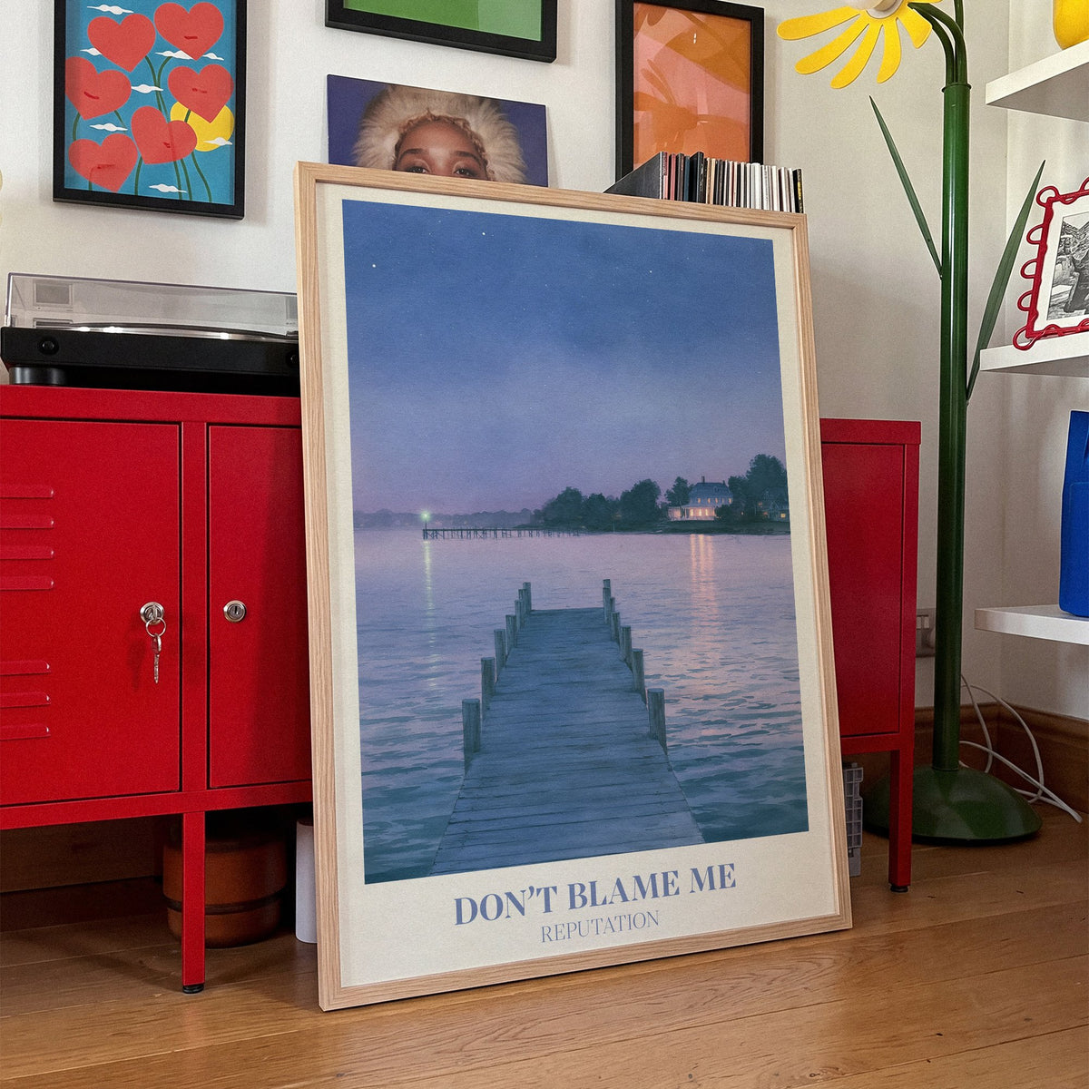 Don’t Blame Me Taylor Swift print of a jetty on a lake at dusk, leaning against red lockers in a colourful living room