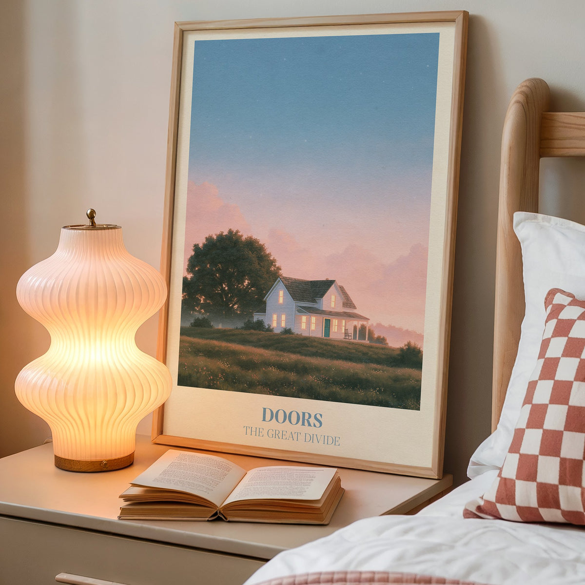 Doors Noah Kahan print of a white farmhouse glowing at dusk, framed on a bedside table beside a lamp