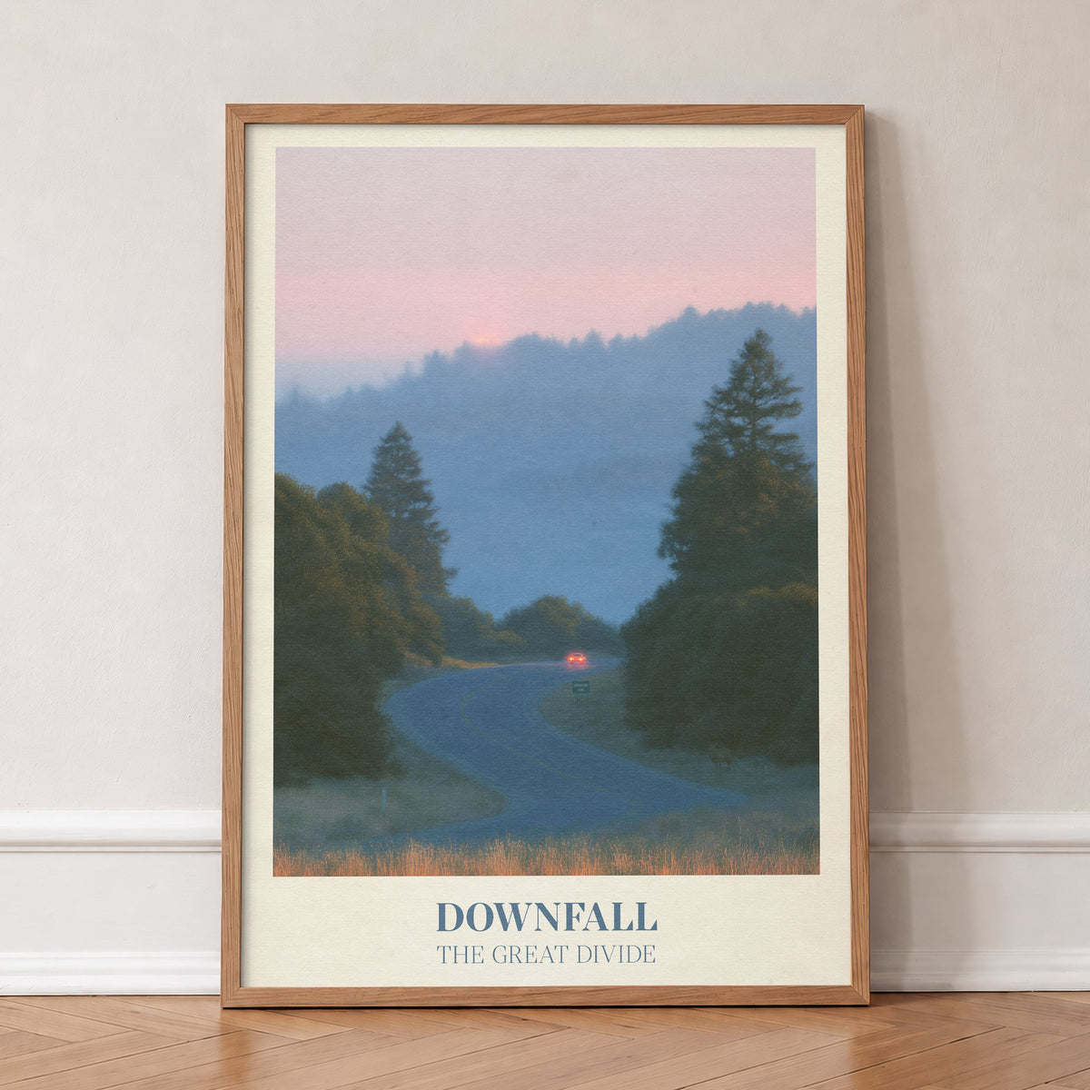 Downfall Noah Kahan print of a winding road through misty pine hills at dusk, in an oak frame, leaning against a wall on a herringbone floor
