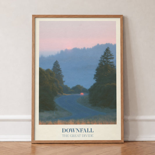 Downfall Noah Kahan print of a winding road through misty pine hills at dusk, in an oak frame, leaning against a wall on a herringbone floor