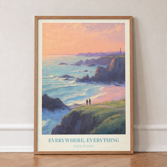 Everywhere, Everything Noah Kahan print of two figures on a clifftop above the sea at sunset, in an oak frame, leaning against a wall on a herringbone floor
