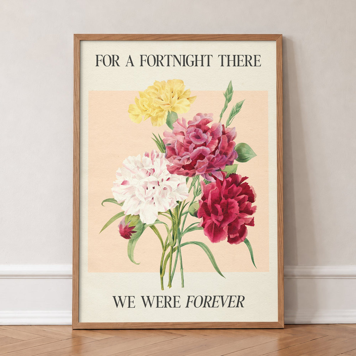 Fortnight Botanical Taylor Swift print of pink, red, white and yellow carnations on peach, in an oak frame, leaning against a wall on a herringbone floor