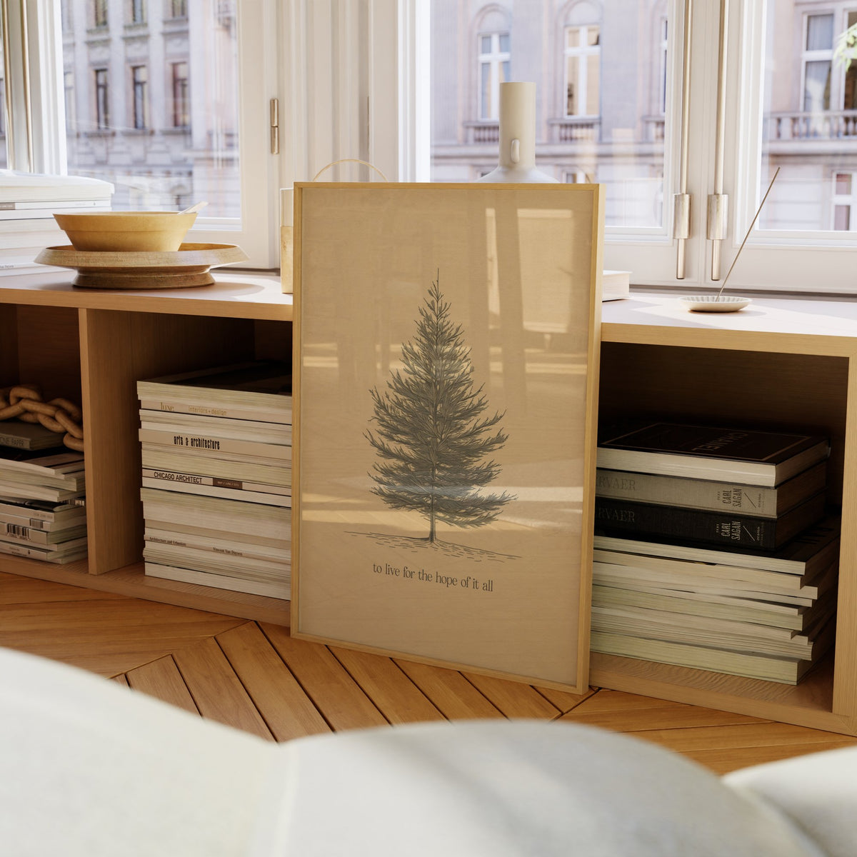 For The Hope Of It All Minimal Taylor Swift print of a pencil-drawn pine tree on cream, framed on a bookcase by a window
