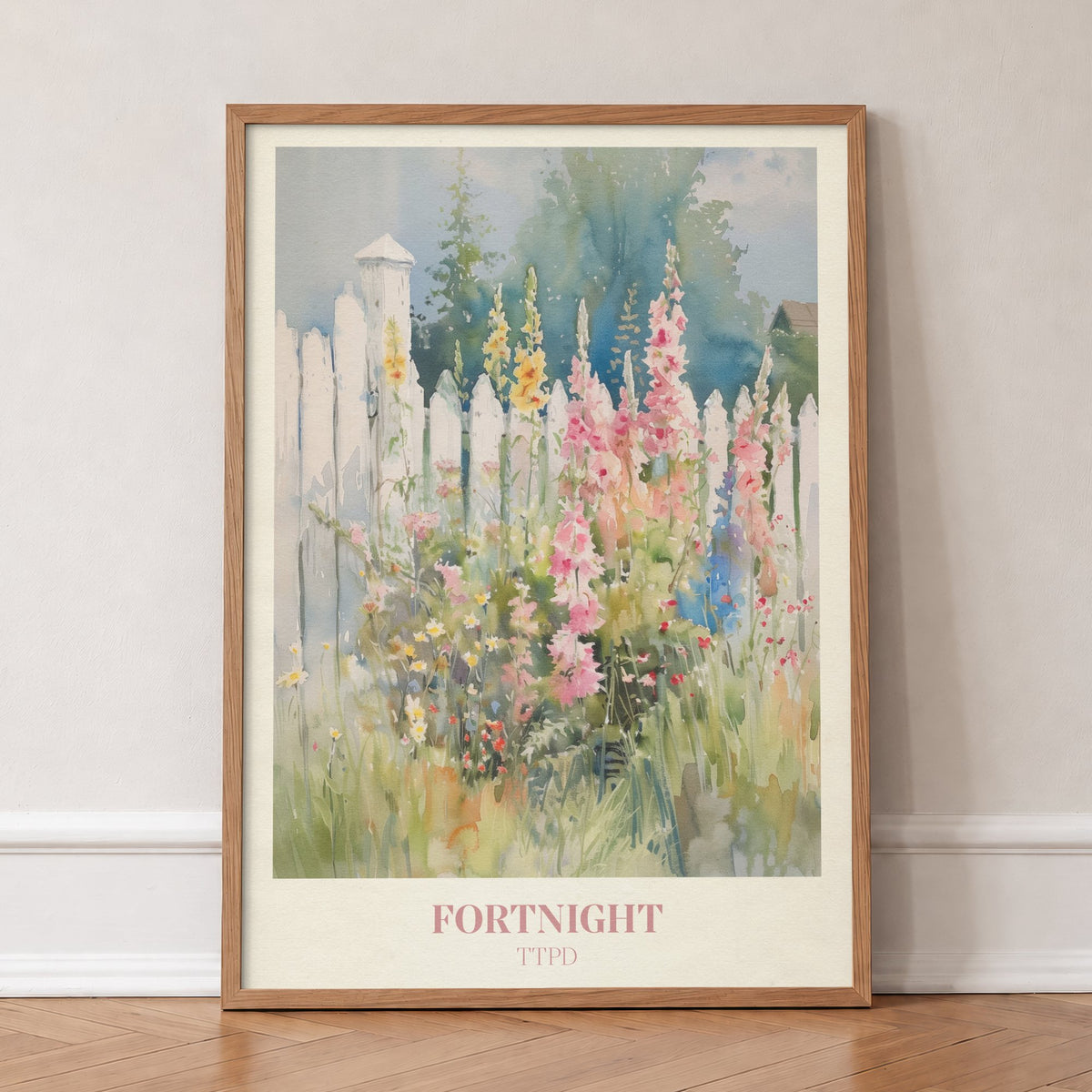 Fortnight Taylor Swift print of hollyhocks and wildflowers by a white picket fence, in an oak frame, leaning against a wall on a herringbone floor