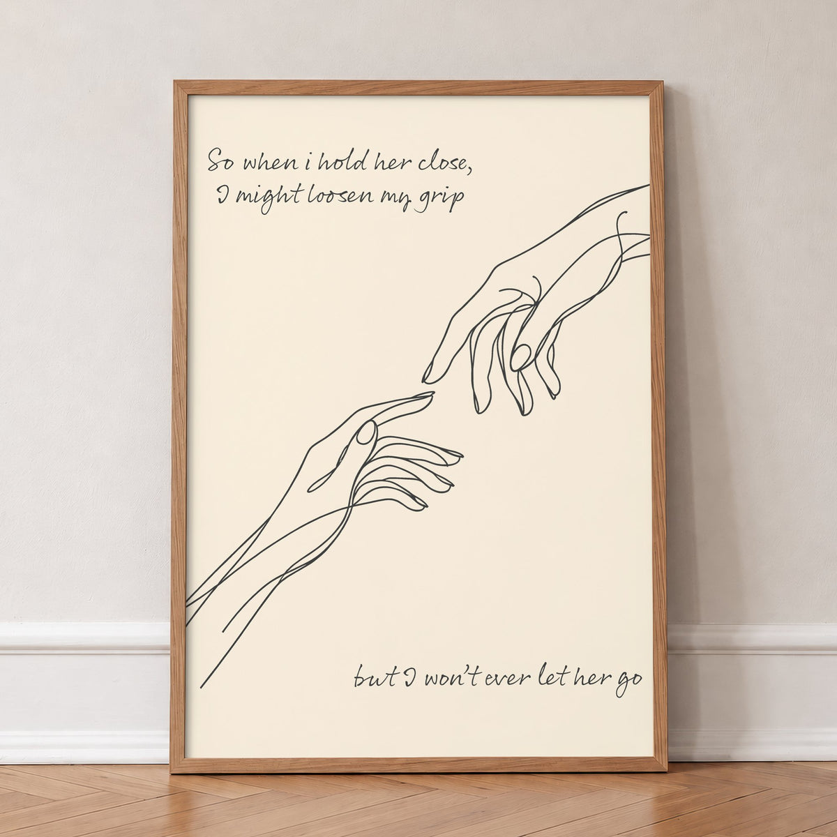 Forever Noah Kahan lyric print, a line drawing of two hands reaching out, in an oak frame, leaning against a wall on a herringbone floor