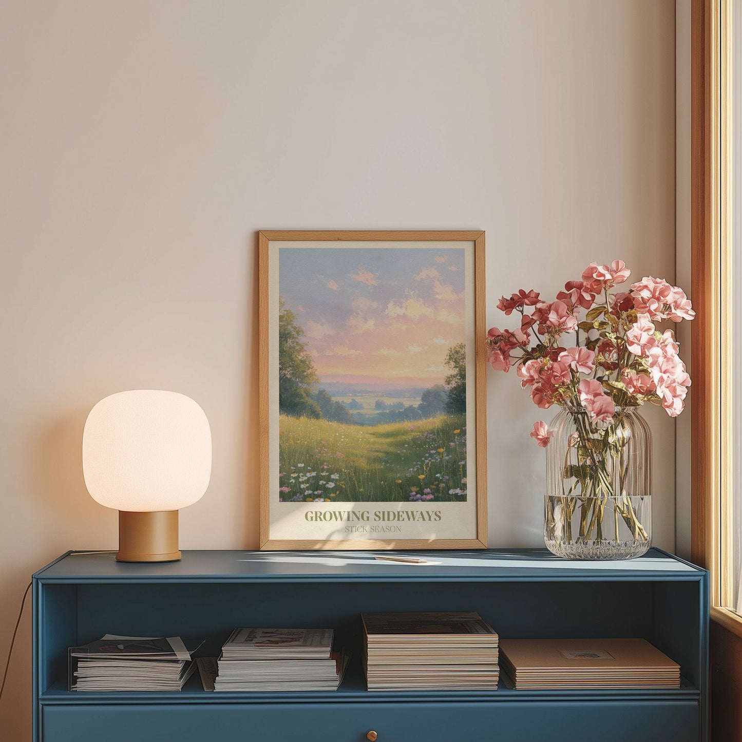 Growing Sideways lyric wall art print inspired by Noah Kahan on a blue sideboard with a lamp and flowers