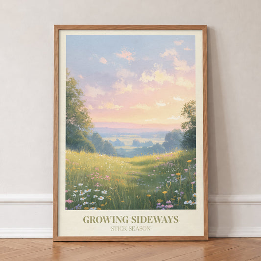 Growing Sideways Noah Kahan print of a wildflower meadow at sunset, in an oak frame, leaning against a wall on a herringbone floor