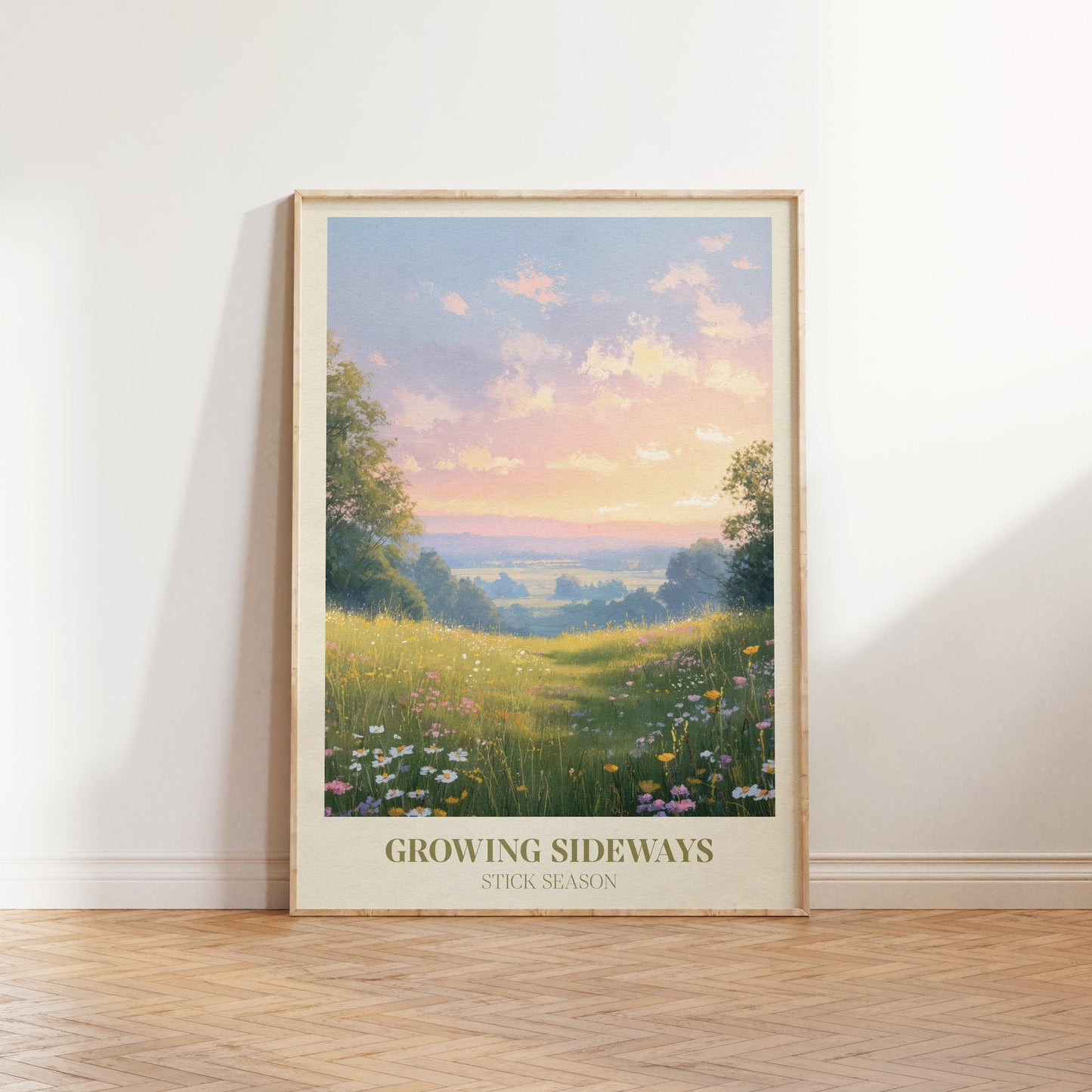 Growing Sideways lyric print inspired by Noah Kahan leaning against a white wall on a wooden herringbone floor in soft daylight