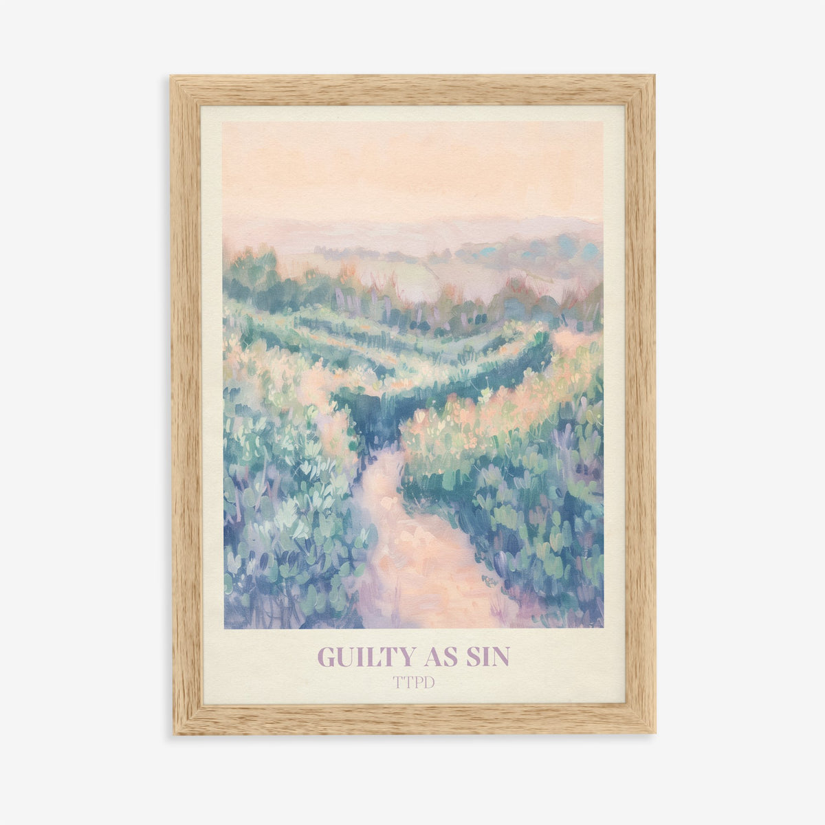 Guilty As Sin Taylor Swift print of a winding path through pastel green hills under a peach sky, in an oak frame on a plain wall