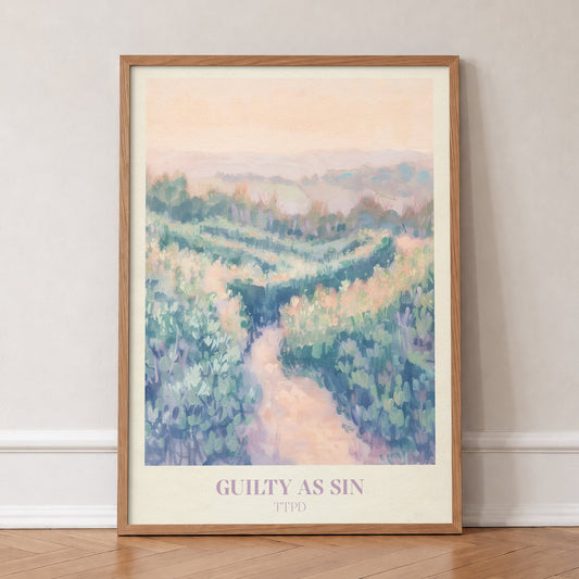 Guilty As Sin Taylor Swift print of a winding path through pastel green hills under a peach sky, in an oak frame, leaning against a wall on a herringbone floor