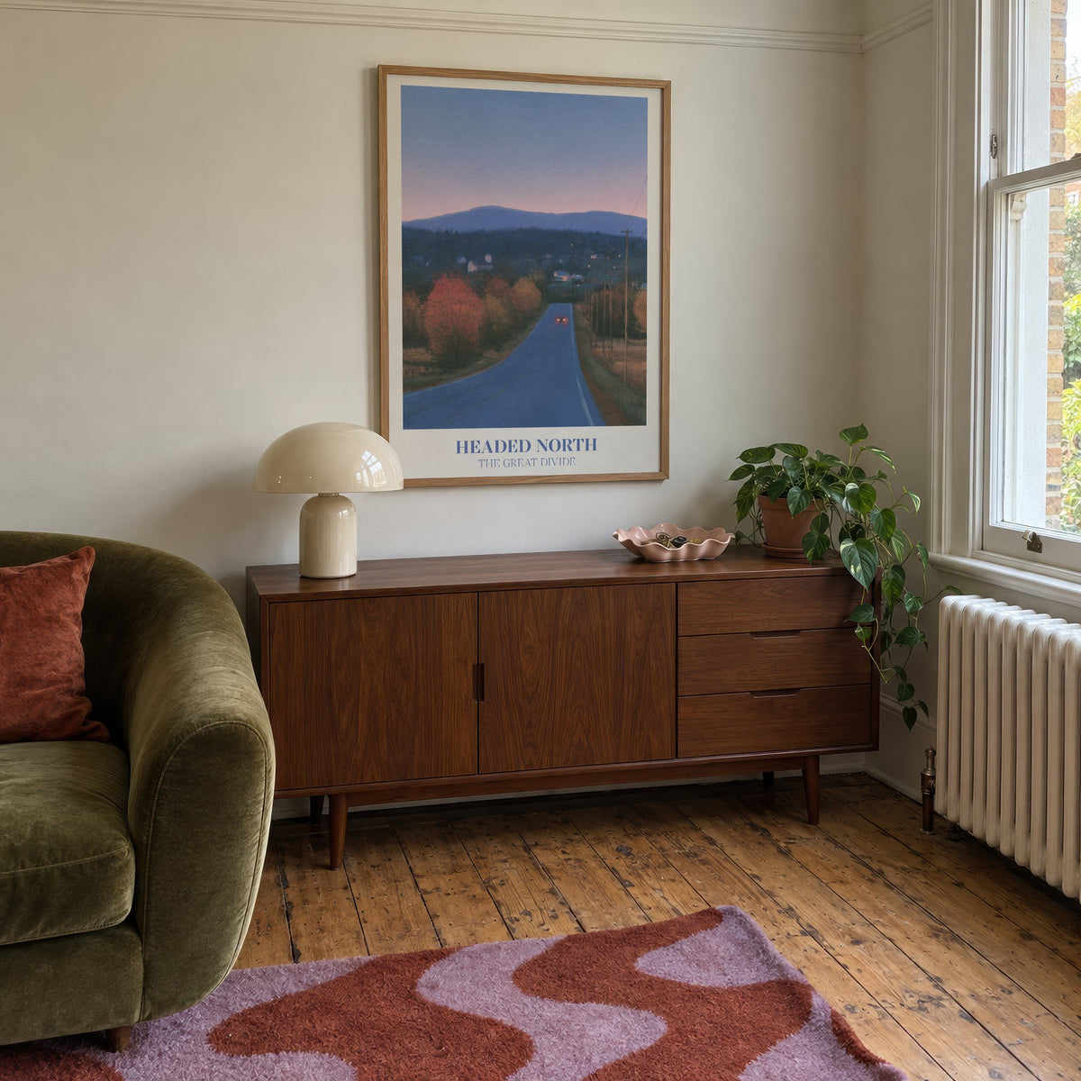 Headed North Noah Kahan print of a country road through autumn trees at dusk, framed above a mid-century sideboard